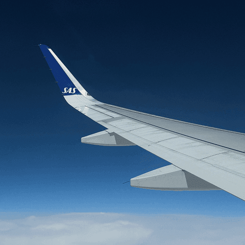 An SAS aircraft wingtip above the clouds